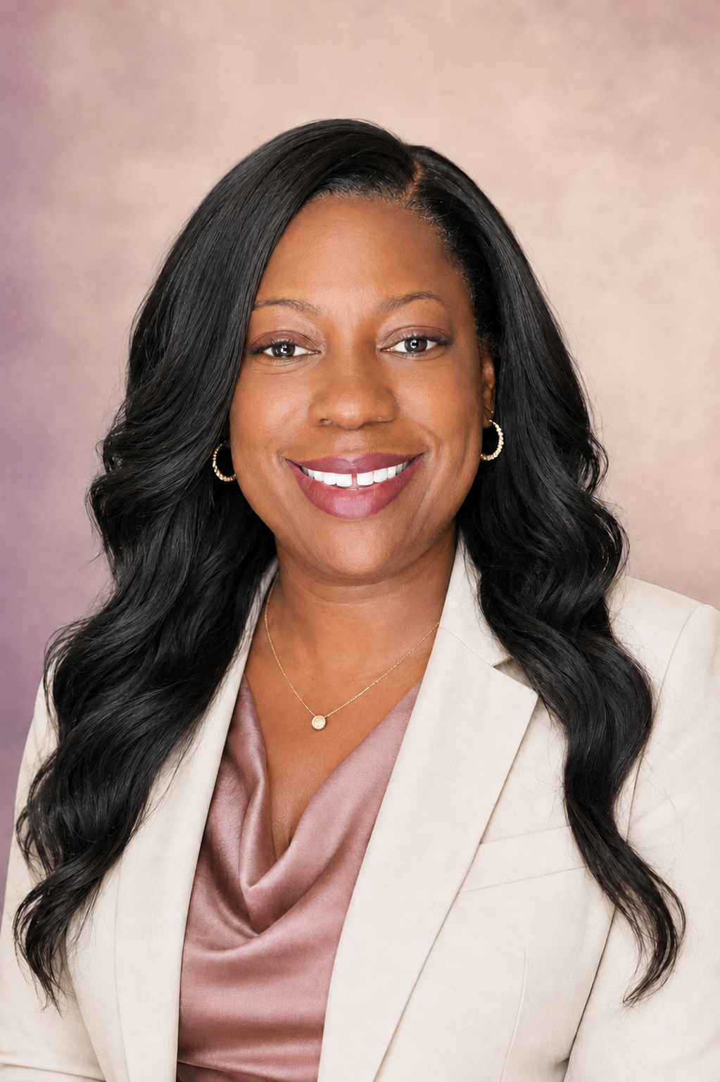 Portrait of Dr. LaTonya Mitchell smiling, wearing a cream blazer over a mauve top.